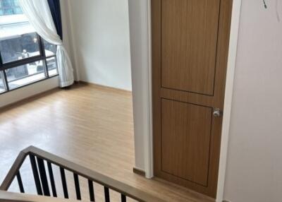 Staircase leading to a room with wooden flooring and a wooden door