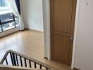 Staircase leading to a room with wooden flooring and a wooden door