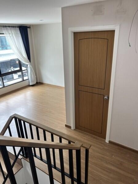 Staircase leading to a room with wooden flooring and a wooden door