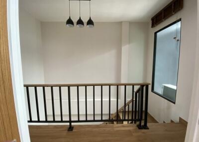 Modern stairway landing with railing and light fixture