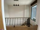 Modern stairway landing with railing and light fixture