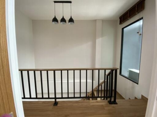 Modern stairway landing with railing and light fixture