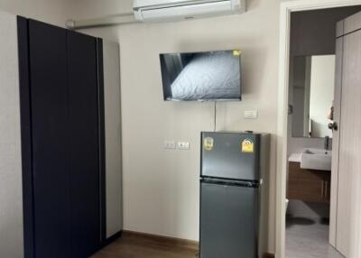 Modern bedroom with AC, TV, and mini-fridge