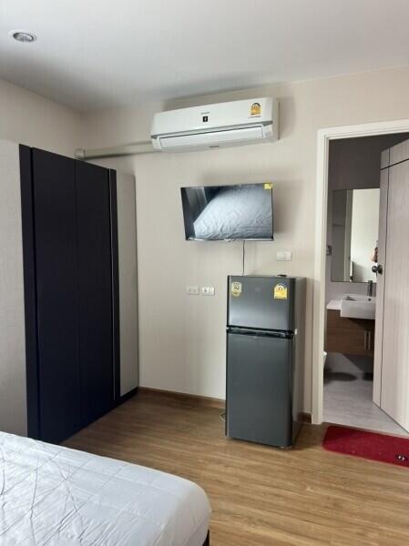 Modern bedroom with AC, TV, and mini-fridge