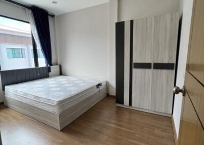 Spacious and bright bedroom with a large window, double bed, and wardrobe