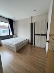 Spacious and bright bedroom with a large window, double bed, and wardrobe