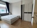 Spacious and bright bedroom with a large window, double bed, and wardrobe