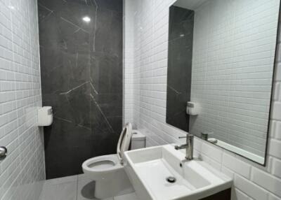 Modern bathroom with white tiles and dark accent wall