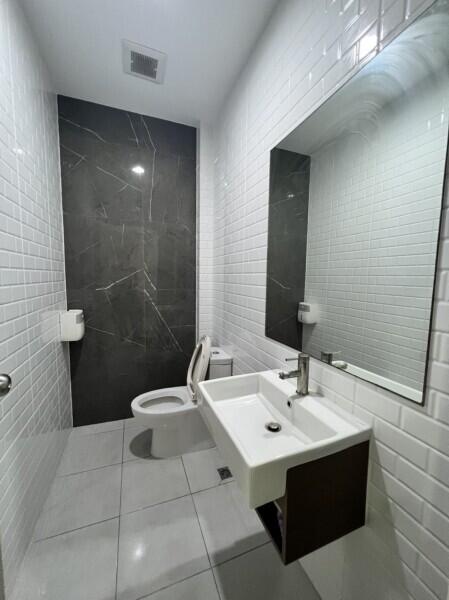 Modern bathroom with white tiles and dark accent wall