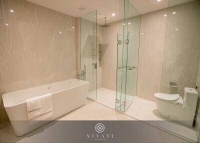 Luxury modern bathroom with a bathtub, glass-enclosed shower, and toilet