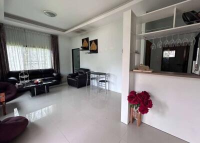 Modern living room with black leather furniture and a small dining area