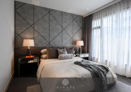 Modern and stylish bedroom with a double bed, bedside tables, and large window