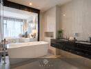 Modern bedroom with en-suite bathroom featuring a standalone bathtub and dual sinks