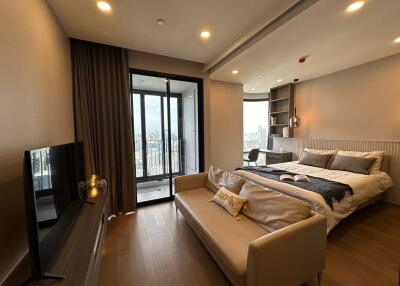 Modern bedroom with city view, cozy bed, sofa, and TV