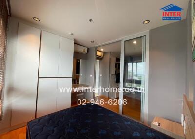 Bedroom with bed, wardrobe, and air conditioning units