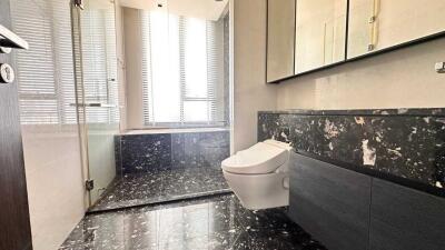 Modern bathroom with large windows, black marble floor, and wall-mounted toilet