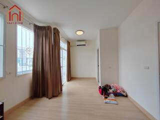 Spacious living room with large windows and wooden flooring