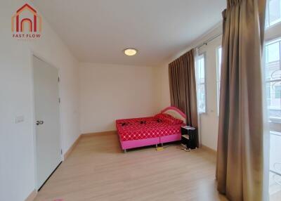 bedroom with a red bed and large windows