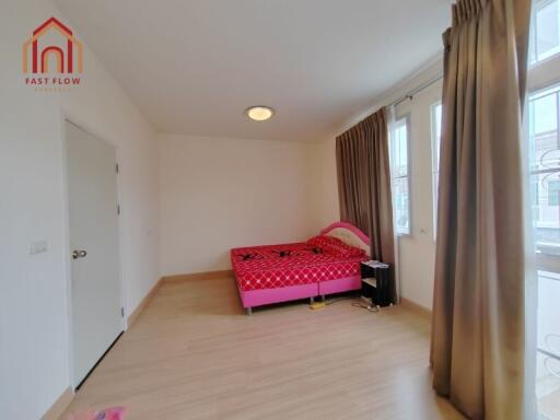 bedroom with a red bed and large windows