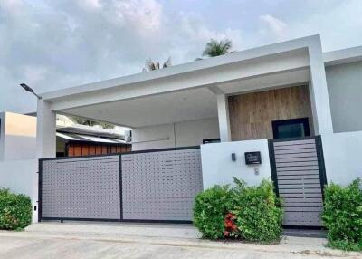 Modern single-story house exterior with a gated front yard