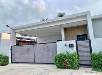 Modern single-story house exterior with a gated front yard