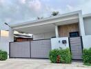 Modern single-story house exterior with a gated front yard