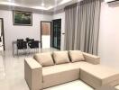 Modern living room with beige sofa and dining area