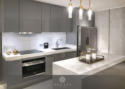 Modern kitchen with grey cabinets, marble countertops, an island, and stainless steel appliances.