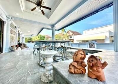 Spacious outdoor patio with decorative sculptures and seating area