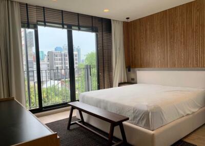 Modern bedroom with large windows and city view