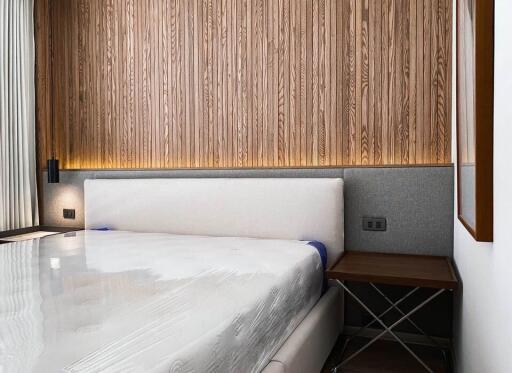 Modern bedroom with a wood accent wall and upholstered bed