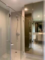 Modern bathroom with glass shower and large mirrored cabinet