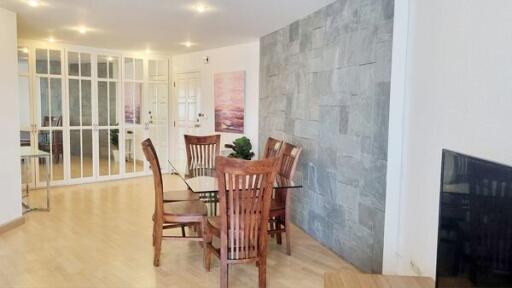 Modern dining area with wooden chairs and glass table