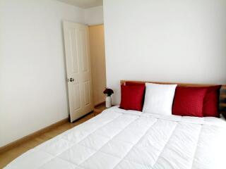 Bedroom with white bedding and red pillows