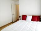 Bedroom with white bedding and red pillows