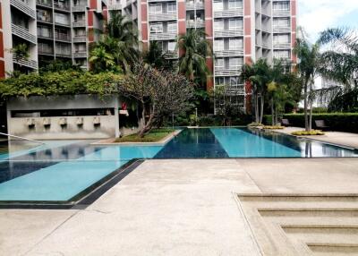 Condominium outdoor swimming pool area with surrounding greenery