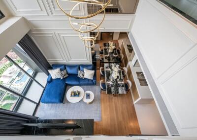 Modern living room with blue sofa and dining area, view from above