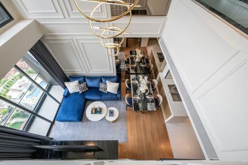 Modern living room with blue sofa and dining area, view from above