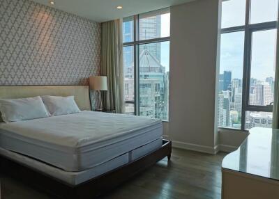 Bright bedroom with large windows and city view