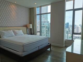 Bright bedroom with large windows and city view