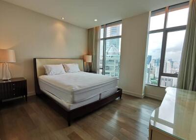 Spacious bedroom with large windows and city view