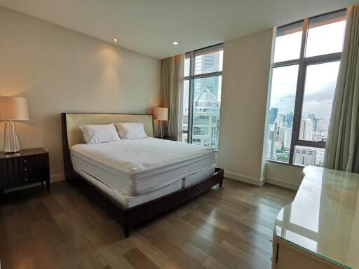 Spacious bedroom with large windows and city view