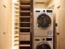 Modern laundry room with washer and dryer stacked neatly inside wooden cabinetry