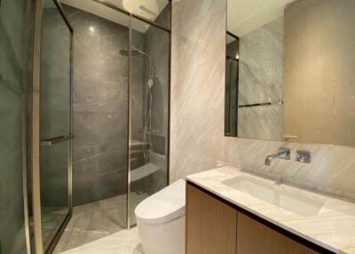 Modern bathroom with glass shower enclosure, sink and toilet