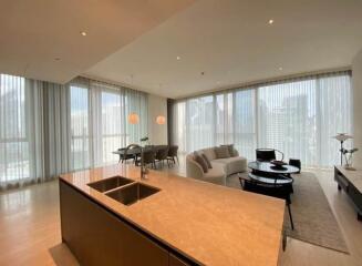 Modern living room with open kitchen and large windows