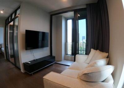 Modern living room with sofa, wall-mounted TV, and balcony access