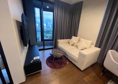 Modern living room with large windows, beige sofa, and a small round coffee table