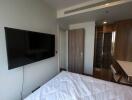 Modern bedroom with wall-mounted TV and workspace