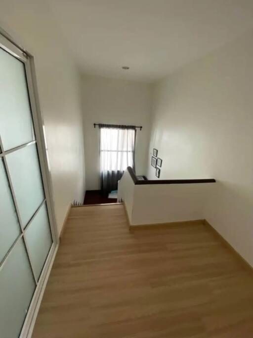 Staircase with wooden flooring and white walls