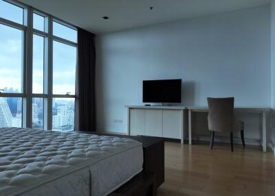 Spacious bedroom with large windows and city view